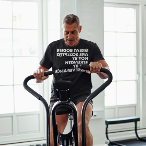 Senior man working out on an elliptical bike - Great-bodies-are-sculpted-not-by-strength-but-by-perseverance