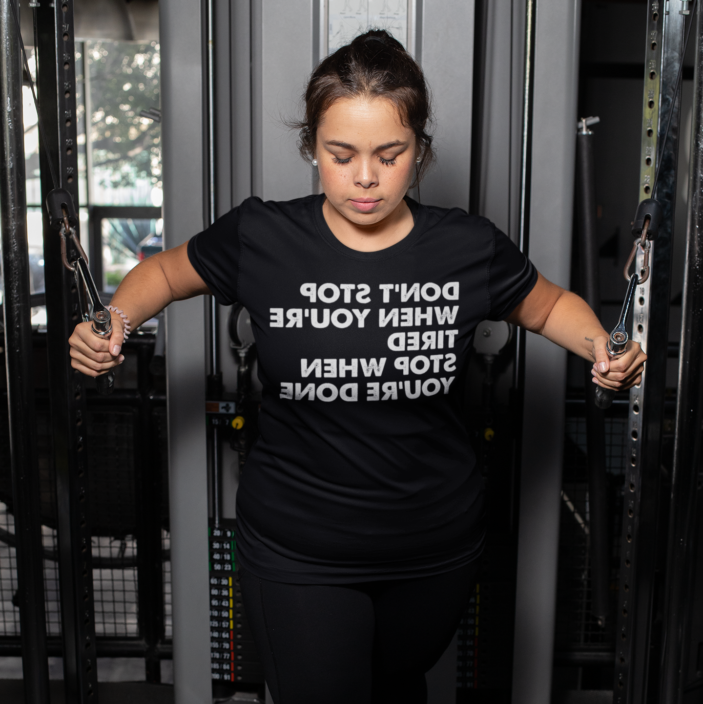 Woman doing cable extensions at a gym - Don't stop when you're tired, stop when you're done.
